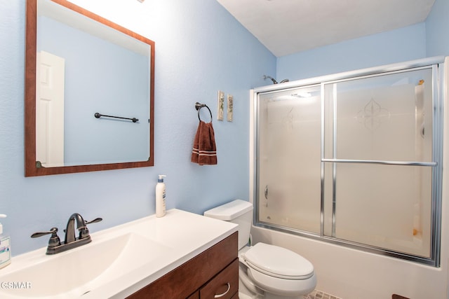 full bathroom with bath / shower combo with glass door, toilet, and vanity