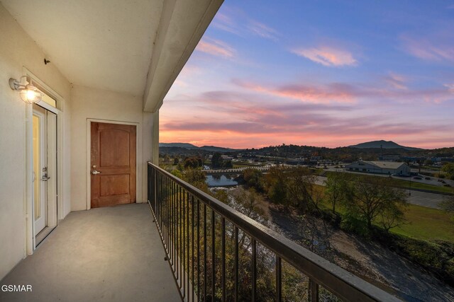 balcony at dusk featuring a mountain view