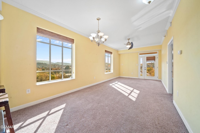 carpeted empty room featuring a mountain view, french doors, a healthy amount of sunlight, and ornamental molding