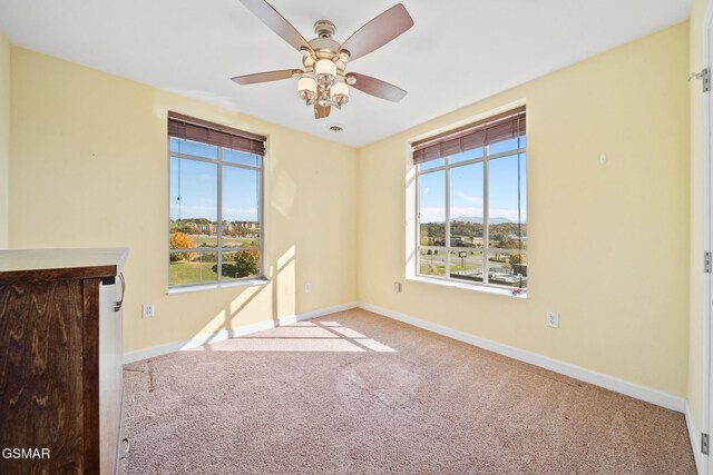 carpeted spare room with ceiling fan