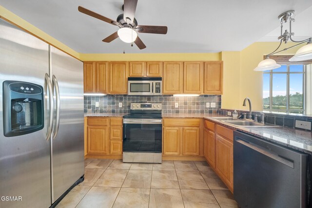 kitchen with appliances with stainless steel finishes, backsplash, ceiling fan, sink, and hanging light fixtures