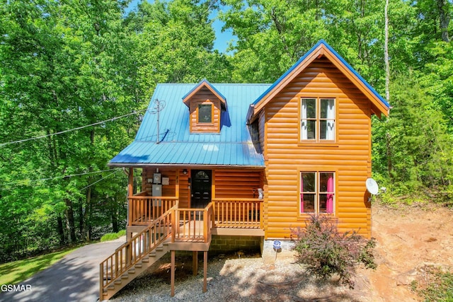 log home featuring covered porch