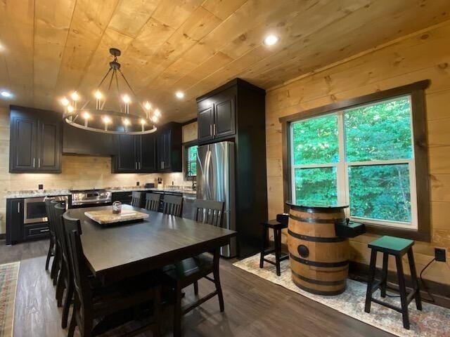 kitchen with plenty of natural light, dark hardwood / wood-style flooring, wood ceiling, and stainless steel fridge