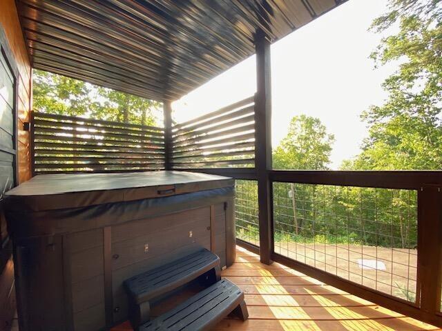 exterior space featuring a wooden deck and a hot tub