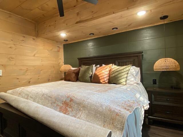 bedroom with wooden ceiling and wood walls