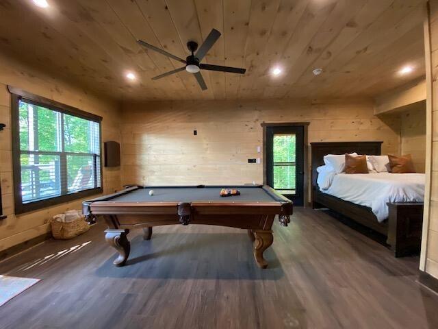 playroom with a wealth of natural light, wood ceiling, wood-type flooring, and wooden walls