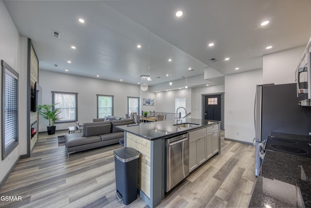 1349 N Baden Dr, Gatlinburg, TN 37738 - kitchen featuring stainless steel appliances, a sink, open floor plan, light wood-type flooring, and dark stone countertops