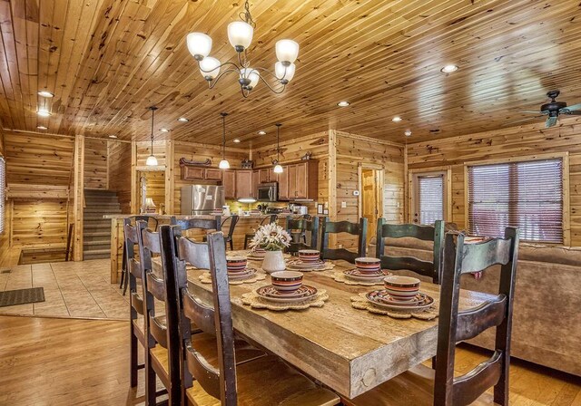 dining area with wooden walls, light hardwood / wood-style flooring, and wood ceiling