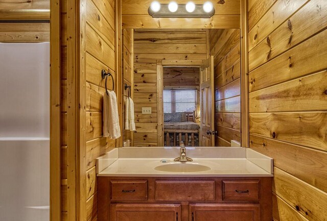 bathroom featuring vanity and wood walls