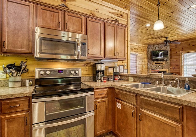 kitchen with appliances with stainless steel finishes, wood ceiling, wood walls, and sink