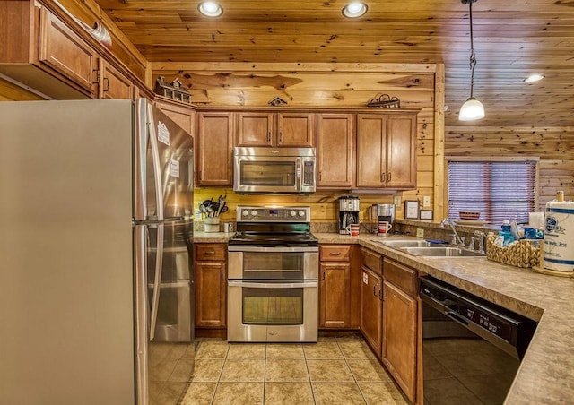 kitchen with sink, hanging light fixtures, wood walls, wood ceiling, and appliances with stainless steel finishes