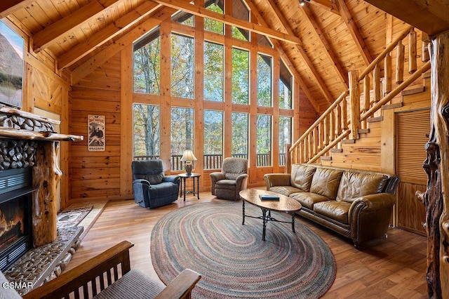 living room with hardwood / wood-style flooring, wooden ceiling, a fireplace, and beamed ceiling