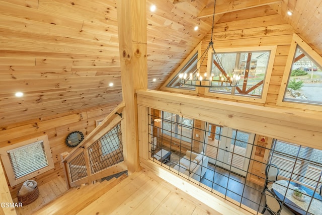 additional living space featuring an inviting chandelier, wooden walls, and vaulted ceiling