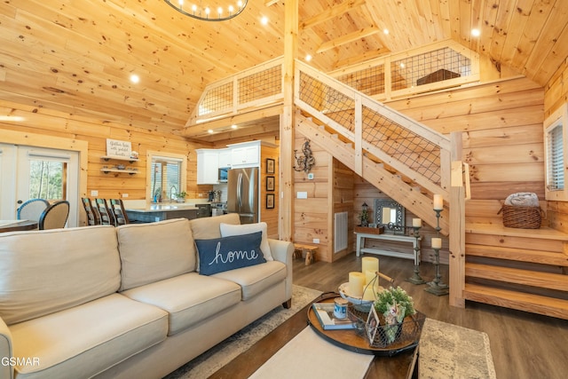 living room with wood ceiling, wooden walls, wood finished floors, and stairs