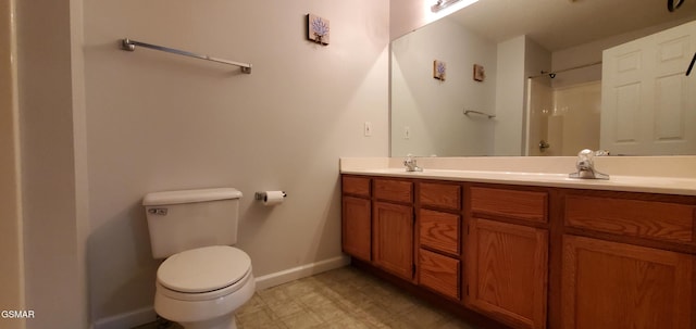 bathroom featuring a shower, baseboards, toilet, and double vanity