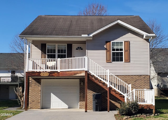 view of front of home featuring covered porch, concrete driveway, and brick siding