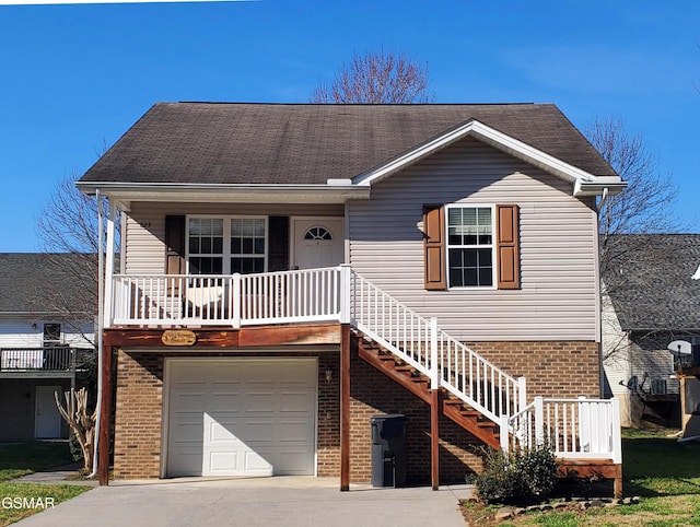 view of front of house featuring brick siding, a porch, stairway, an attached garage, and driveway