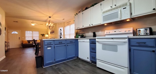 kitchen featuring a peninsula, white appliances, blue cabinetry, and a wealth of natural light