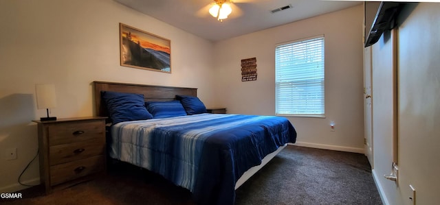 bedroom with dark colored carpet, visible vents, and baseboards