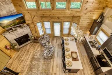937 Pine Valley Way, Sevierville, TN 37862 - living area featuring a fireplace, wood finished floors, wood walls, and a towering ceiling