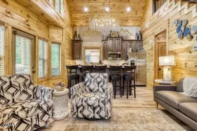937 Pine Valley Way, Sevierville, TN 37862 - living room with wood walls, a towering ceiling, light wood finished floors, a chandelier, and wood ceiling