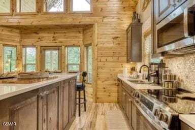 937 Pine Valley Way, Sevierville, TN 37862 - kitchen with stainless steel appliances, wooden walls, light countertops, plenty of natural light, and a high ceiling