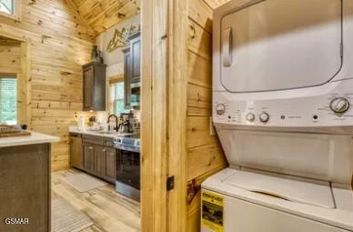 937 Pine Valley Way, Sevierville, TN 37862 - laundry area with stacked washer / dryer, wood walls, and light wood-style flooring