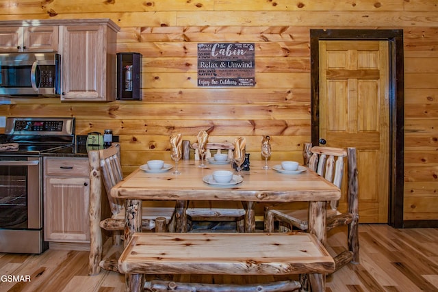 1156 Hemlock Dr, Gatlinburg, TN 37738 - dining room featuring light wood-style flooring and wood walls