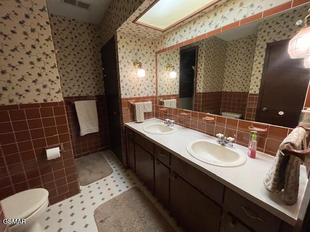 bathroom featuring tile walls, tile patterned floors, vanity, and toilet