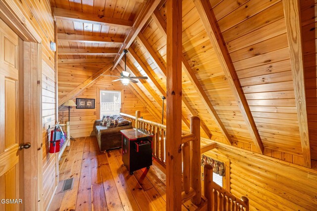 bonus room with wood walls, vaulted ceiling with beams, hardwood / wood-style flooring, ceiling fan, and wooden ceiling