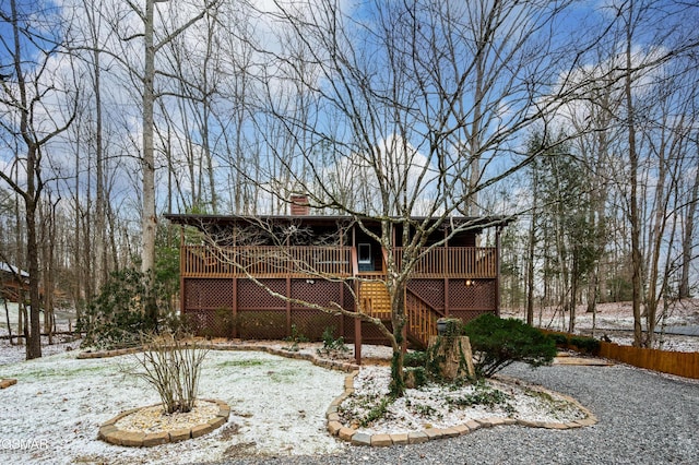 snow covered rear of property featuring a wooden deck