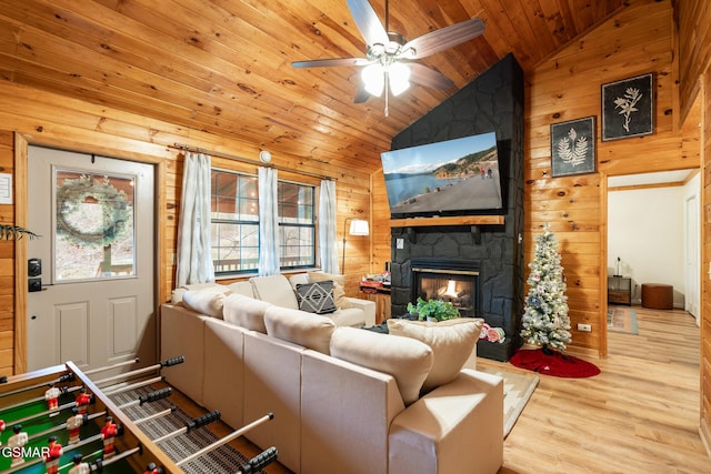 living room with wooden walls, a fireplace, wood ceiling, and vaulted ceiling