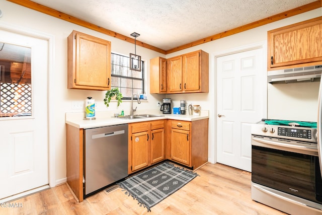 kitchen with a textured ceiling, ventilation hood, stainless steel appliances, sink, and decorative light fixtures