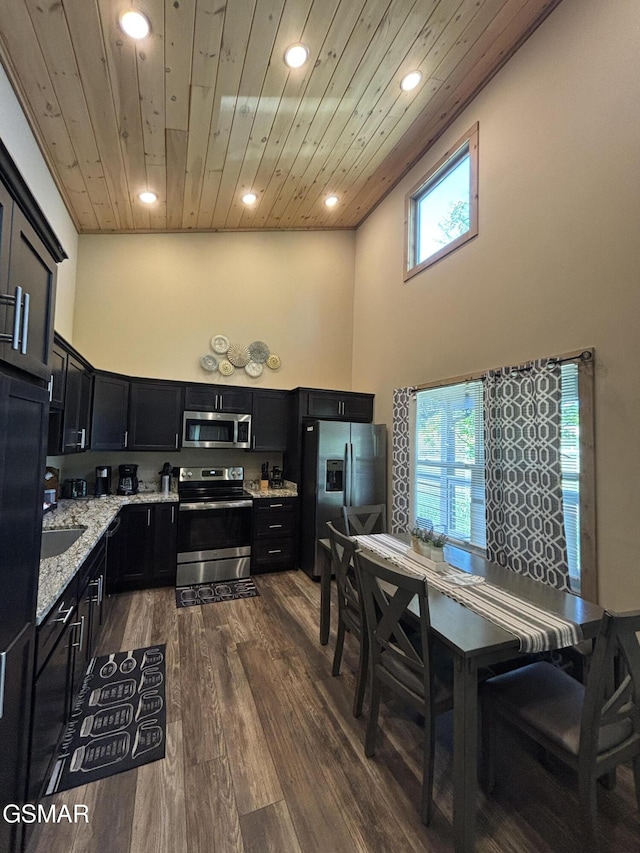 3412 Worth Rd, Sevierville, TN 37876 - kitchen featuring appliances with stainless steel finishes, dark cabinetry, recessed lighting, wood ceiling, and light stone countertops