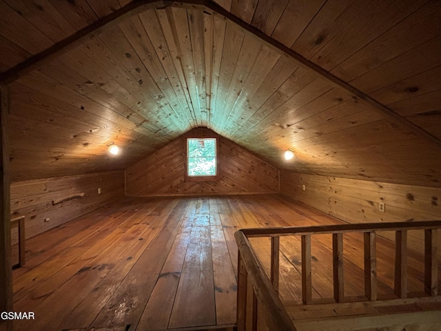 additional living space with wood walls, lofted ceiling, wood-type flooring, and wooden ceiling