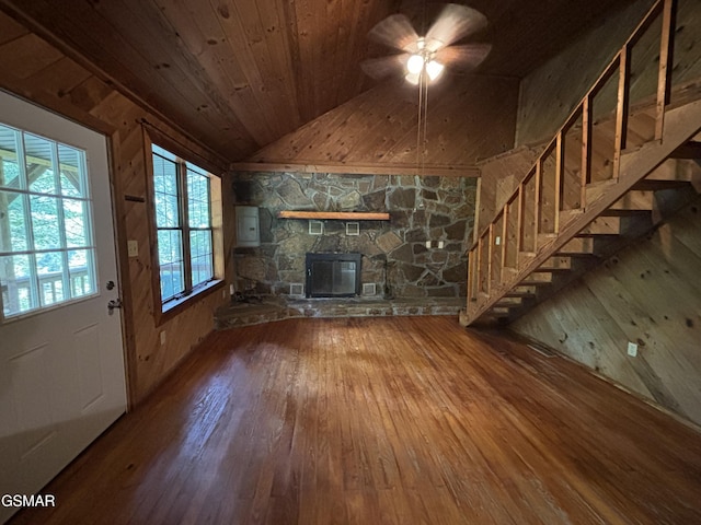 unfurnished living room featuring a stone fireplace, vaulted ceiling, wooden ceiling, electric panel, and hardwood / wood-style floors