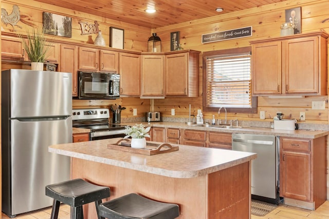 kitchen featuring wood ceiling, a sink, a kitchen island, wooden walls, and stainless steel appliances