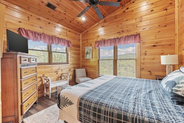 bedroom with lofted ceiling, wood finished floors, wooden walls, and wood ceiling