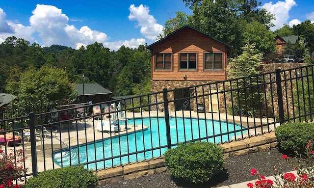 community pool featuring a patio and fence
