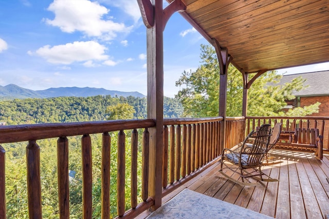 deck with a forest view and a mountain view