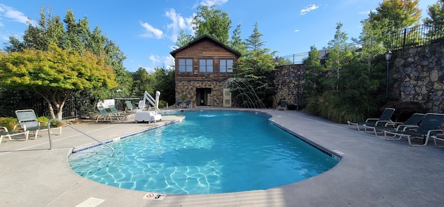 community pool featuring fence and a patio area