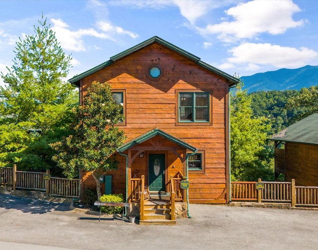 view of front of house featuring a mountain view and fence