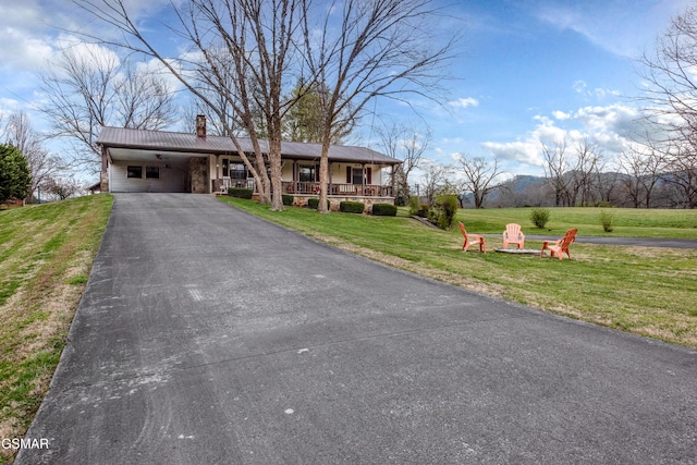311 E Chestnut Hill Rd, Townsend, TN 37882 - view of front of home featuring metal roof, an outdoor fire pit, a front yard, driveway, and a carport