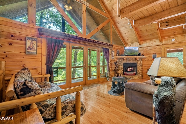 living area with wooden walls, a fireplace, wood finished floors, wood ceiling, and beamed ceiling