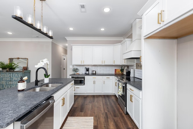 kitchen featuring premium range hood, appliances with stainless steel finishes, white cabinets, and sink