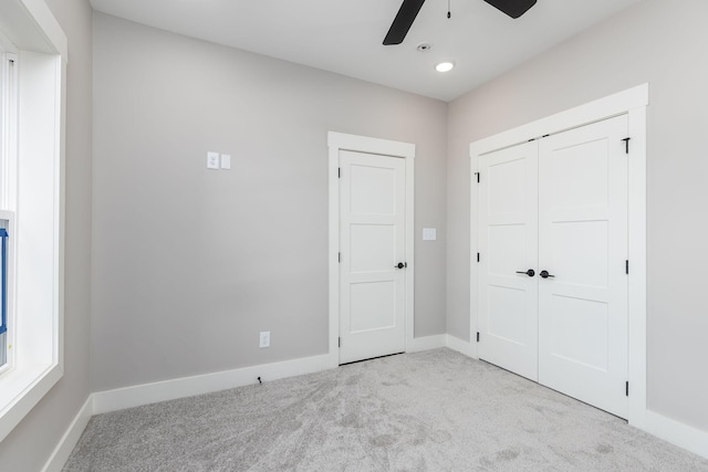 unfurnished bedroom featuring light carpet, ceiling fan, and a closet