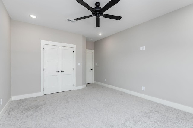 unfurnished bedroom with light carpet, ceiling fan, and a closet