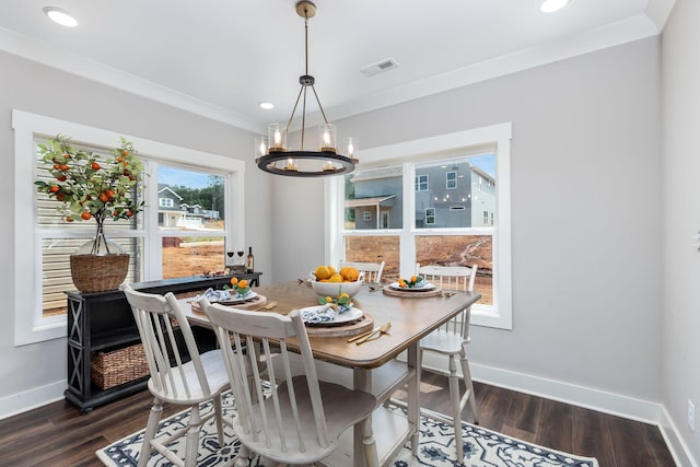 dining room with dark hardwood / wood-style flooring, ornamental molding, and an inviting chandelier