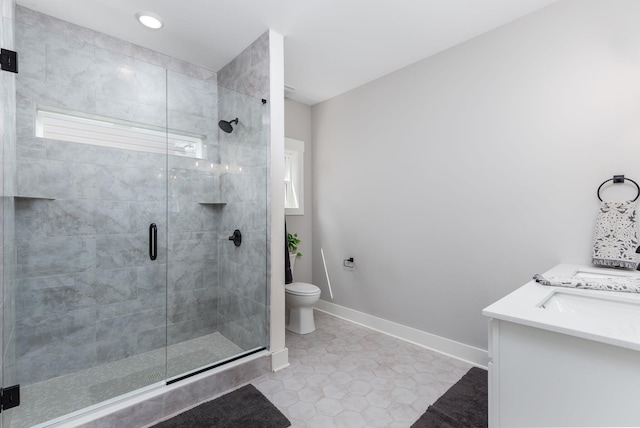 bathroom featuring toilet, vanity, tile patterned floors, plenty of natural light, and an enclosed shower