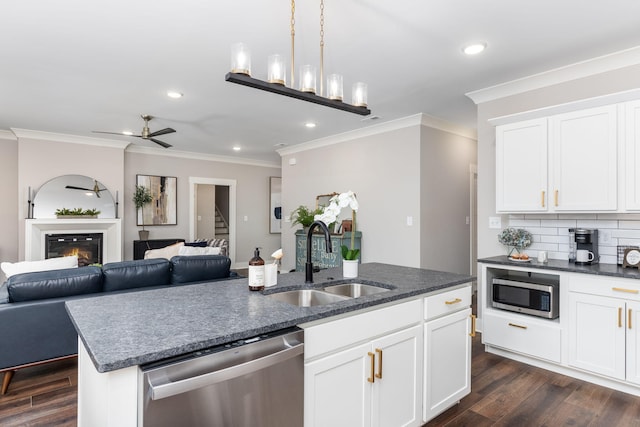 kitchen featuring sink, dark wood-type flooring, an island with sink, stainless steel appliances, and white cabinets